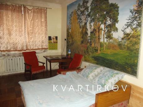 The apartment has two sofas, wall units, fridge, TV, dishes,